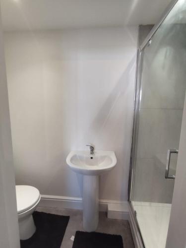 a bathroom with a sink and a shower and a toilet at En-Suite Double-Bedroom in the Heart of Salford Manchester CR4 Perfect for Short Stays in Manchester