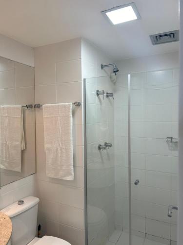 a bathroom with a glass shower with a toilet at Fusion e Vision Flats in Brasilia