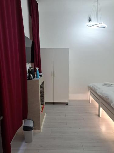 a kitchen with white cabinets and a bed in a room at NEW - Old Town Pearl Apartments in Sarajevo