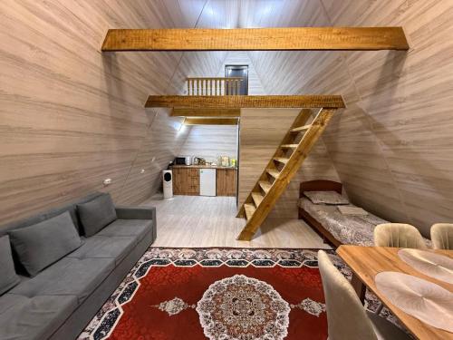 a room with a couch and a staircase in a house at Miman house Kolsay in Kurmenty