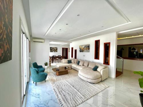 a living room with a couch and two chairs at Villa Olivia in El Guecheïne