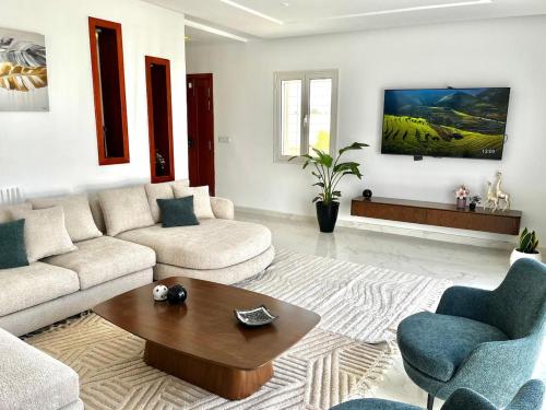a living room with a couch and a coffee table at Villa Olivia in El Guecheïne