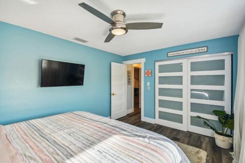 a blue bedroom with a bed and a ceiling fan at Luxury heated-pool home blocks from the beach in Tarpon Springs