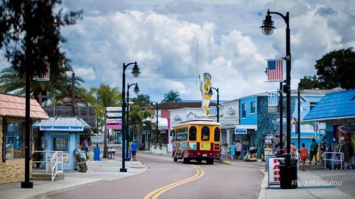 a trolley car driving down a street in a town at Luxury heated-pool home blocks from the beach in Tarpon Springs