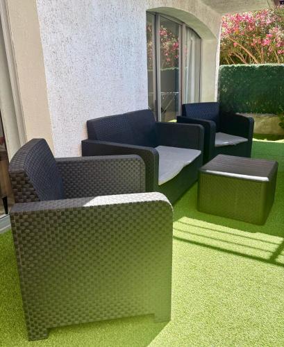 - un groupe de chaises et de tables dans une pièce avec pelouse dans l'établissement Sous le soleil de Martigues, à Martigues