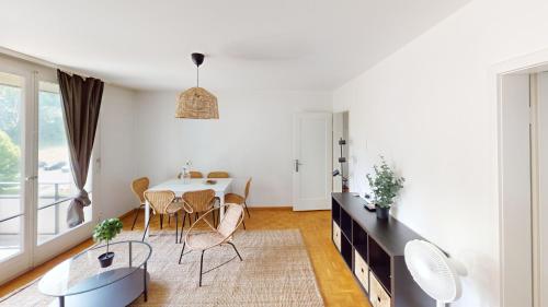 a white living room with a table and chairs at Comfort Meets Simplicity 2BR Apartment in Zürich
