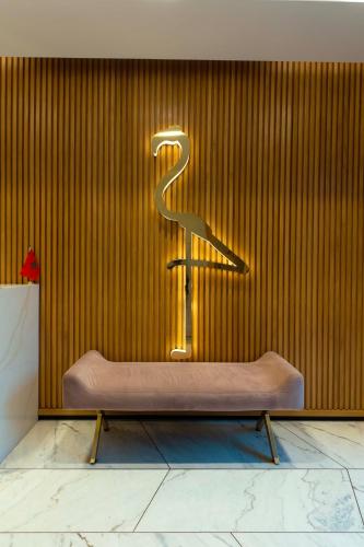 a bench in front of a wall with a sign at Flamant Rose Appart Hotel in Tangier