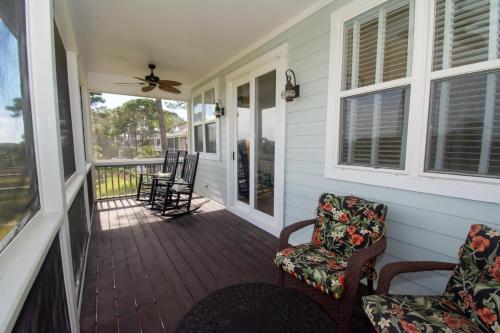 a porch with chairs and a ceiling fan at 83 Ocean Creek Blvd in Fripp Island
