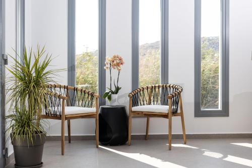two chairs sitting in a room with windows at calmare collection hotel in Plaka