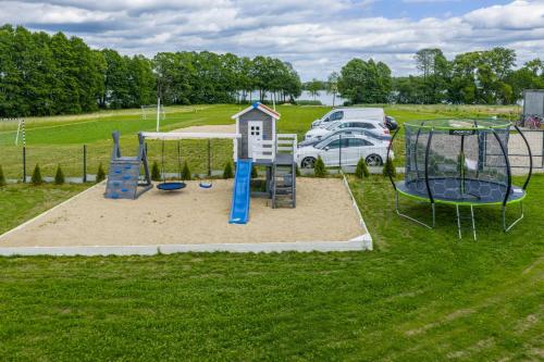 a playground in a park with a car parked at Osada Kalwa in Tylkowo