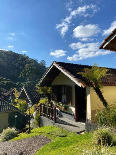 a house with a mountain in the background at Chalés 4 Estações in Monte Verde