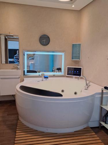 une grande baignoire blanche dans une salle de bain avec une fenêtre dans l'établissement Séjour Prestige Vue Mer, Jacuzzi, Piscine, à Oulad Akkou