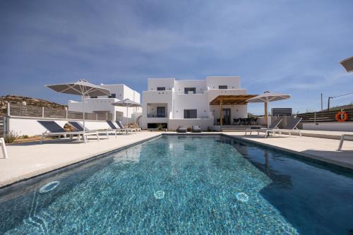 a villa with a swimming pool in front of a house at calmare collection hotel in Plaka