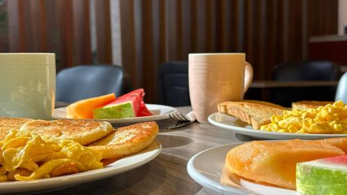 ein Tisch mit Tellern voller Frühstücksspeisen darauf in der Unterkunft DUSANO BOUTIQUE HOTEL in Santa Marta