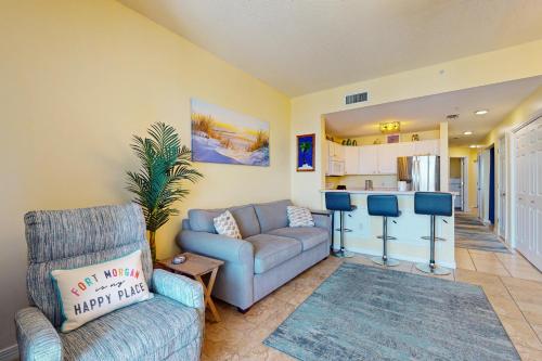 a living room with a couch and a kitchen at The Dunes 704 in Gulf Shores