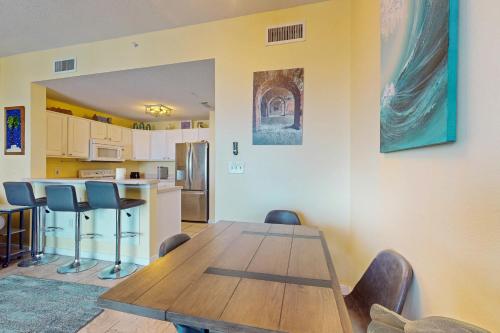a dining room with a wooden table and chairs at The Dunes 704 in Gulf Shores