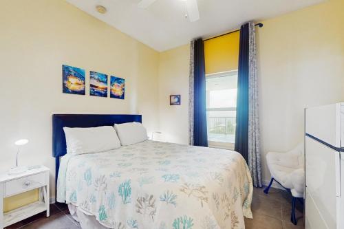 a bedroom with a bed and a window at The Dunes 704 in Gulf Shores