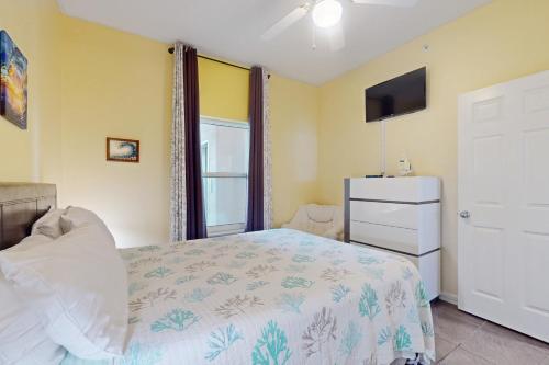 a bedroom with a bed and a dresser and a television at The Dunes 704 in Gulf Shores