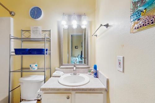 a bathroom with a sink and a toilet and a mirror at The Dunes 704 in Gulf Shores