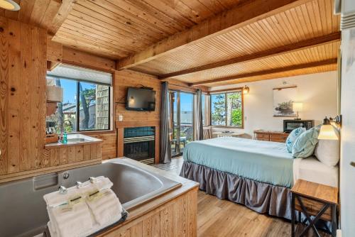 a log cabin bedroom with a bed and a tub at The Inn at Manzanita in Manzanita
