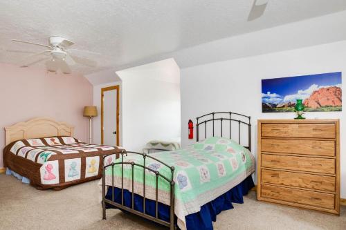 a bedroom with two beds and a dresser at Hacienda Roja - The Cedars #7 at Wind Walker Homestead in Spring City