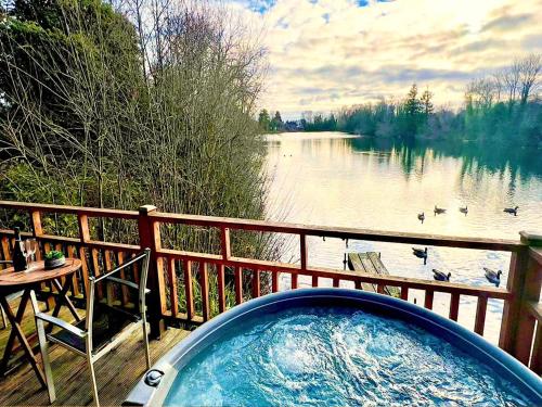 a hot tub on a deck with a view of a lake at Holly Lodge 12 Hot Tub in York