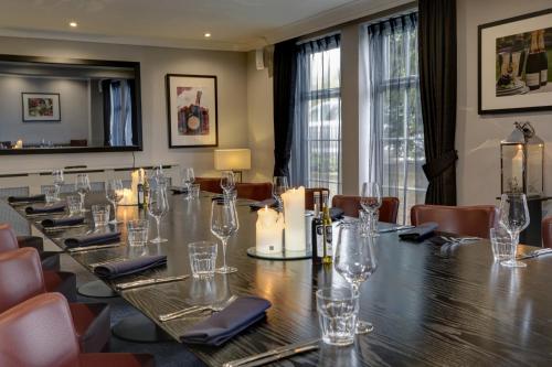 a long table in a room with glasses and candles at Crowne Plaza East Midlands Airport by IHG in Derby