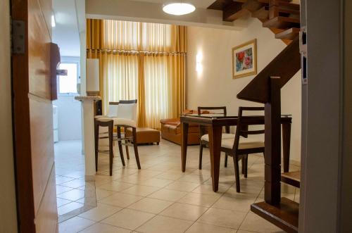 a living room with a dining room table and chairs at Hotel City Hall in São José dos Campos