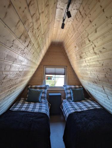two beds in a small room in a tiny house at Domki Słodka Magnolia in Karwia