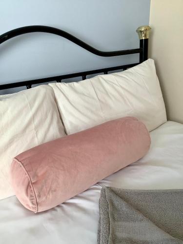 a pink pillow sitting on top of a bed at Lorton Villa with a Log Burner in Saint Helens
