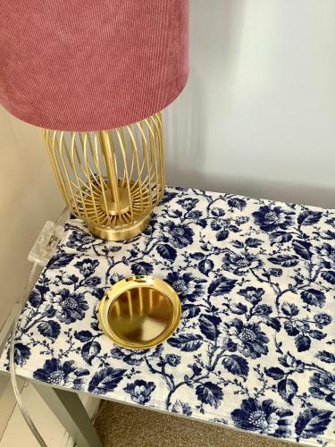 a table with a lamp on top of a blue and white table at Lorton Villa with a Log Burner in Saint Helens
