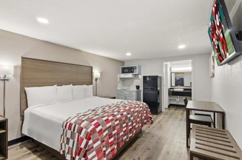 a hotel room with a large bed and a kitchen at Red Roof Inn Wytheville in Wytheville