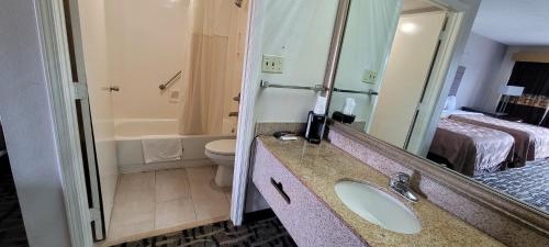 a bathroom with a sink and a toilet and a mirror at Motel 6 Jackson MS Southwest in Jackson