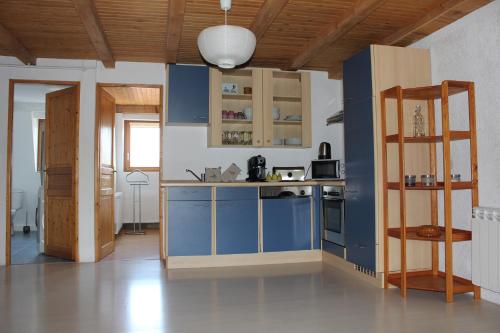 une cuisine avec des placards bleus et une échelle dans l'établissement NaNa's, à Colmar