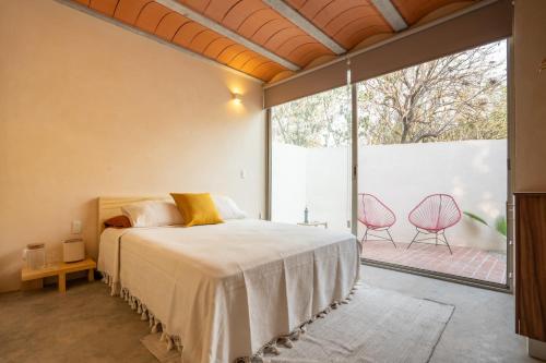a bedroom with a bed and a large window at Casa Oma 03 in Tepoztlán