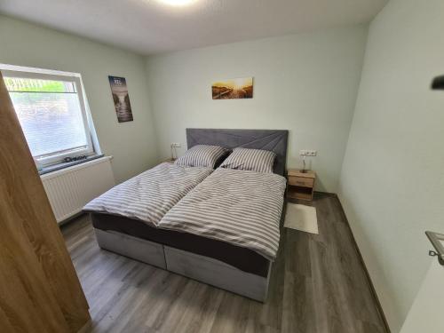 Un dormitorio con una cama en una habitación con ventana. en Gästehaus Waldliebe, 