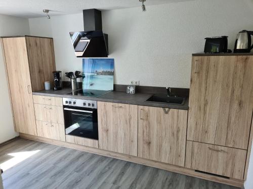 Una cocina con gabinetes de madera y un fregadero. en Gästehaus Waldliebe, 