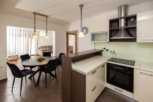 a kitchen and living room with a table and a dining room at Apartman Gulin II in Crikvenica
