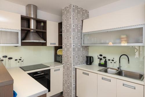 a kitchen with white cabinets and a sink at Apartman Gulin II in Crikvenica