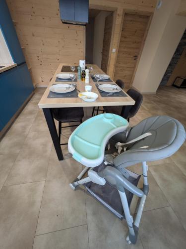 une table en bois avec une chaise bleue et une table et une chaise suggèrent dans l'établissement Gîte La vie clerc, à Les Combes