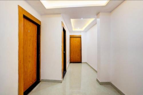 a hallway with two doors and white walls and tile floors at Golden M Riz Hotel & Restuarant in Lucknow