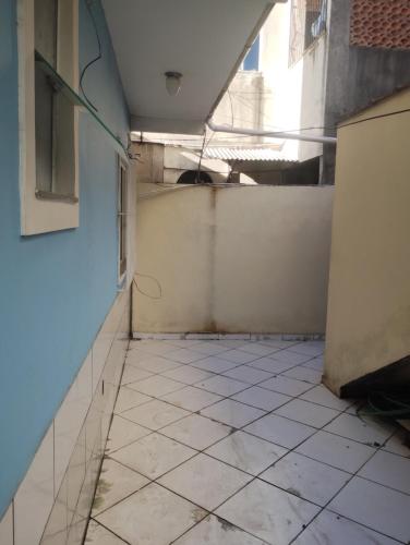 a room with a tiled floor and a wall at Kitnet jardim Campomar in Rio das Ostras