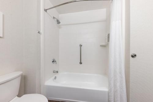 a white bathroom with a shower and a toilet at Hampton Inn Phoenix Midtown Downtown Area in Phoenix