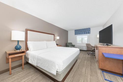 a bedroom with a bed and a desk and a television at Hampton Inn Phoenix Midtown Downtown Area in Phoenix