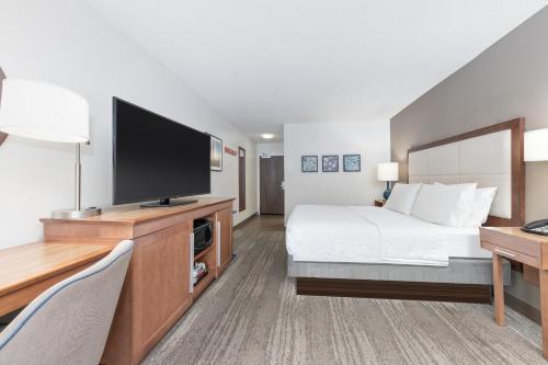 a hotel room with a bed and a flat screen tv at Hampton Inn Phoenix Midtown Downtown Area in Phoenix