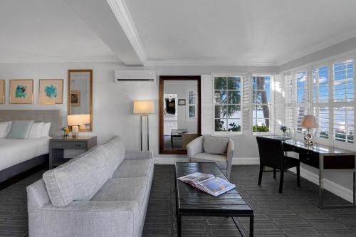 a living room with a couch and a bed and a desk at The Pillars Hotel & Club in Fort Lauderdale