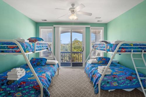 a bedroom with two bunk beds and a balcony at 12 Sea Mist in Fripp Island