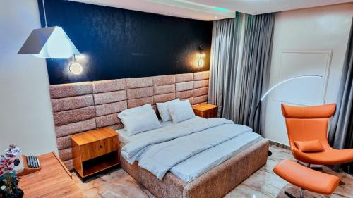 a bedroom with a bed and a chair in it at Redbox Luxury Apartments in Port Harcourt