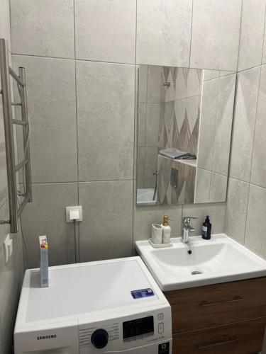 a bathroom with a sink and a mirror at Уютная квартира в ЖК Alpamys в центре in Astana