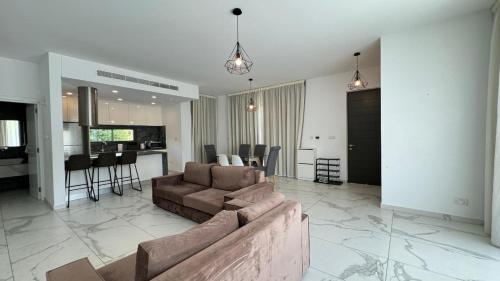 a living room with a couch and a kitchen at Modern 3 bedroom villa with pool in Paphos
